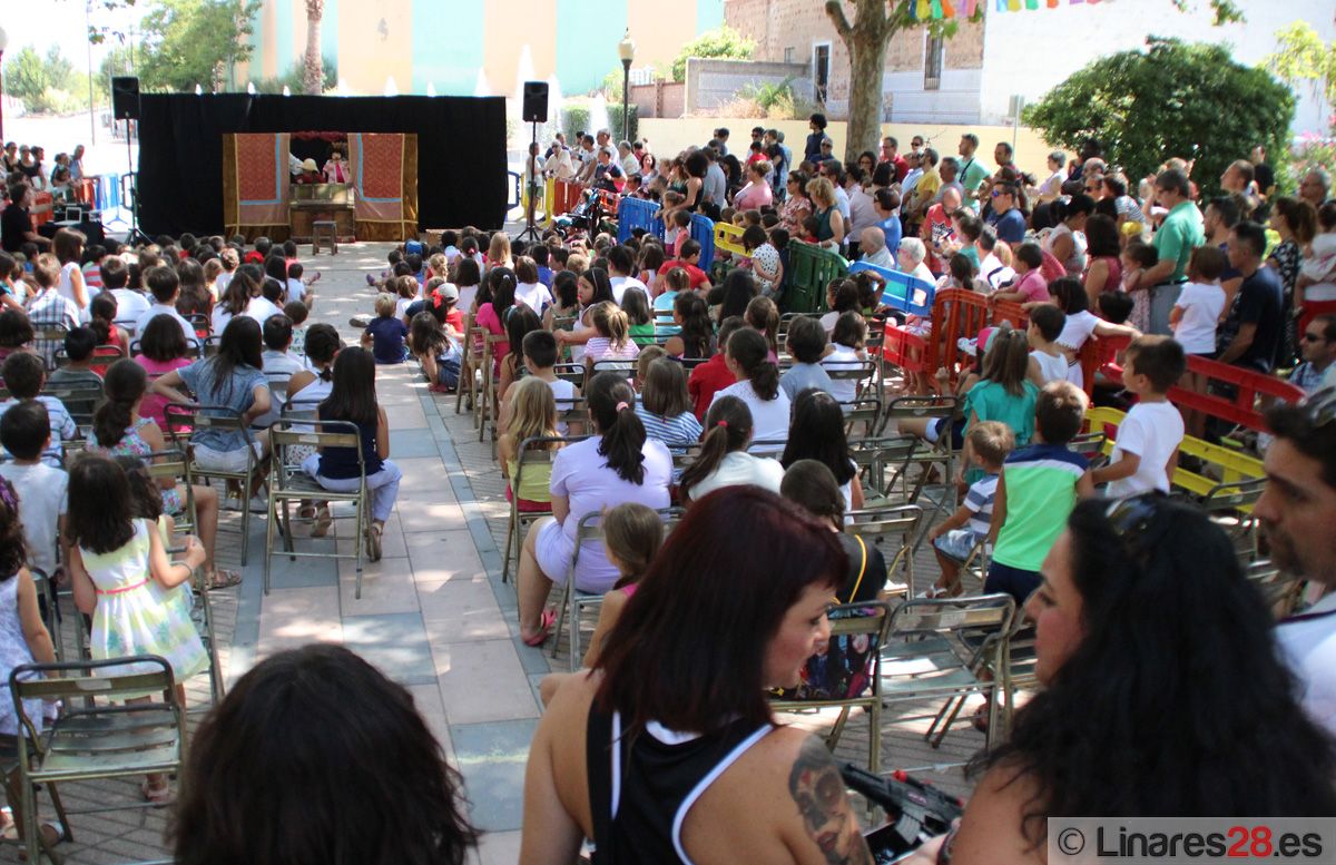 Padres. madres, niños y niñas disfrutando del teatro de títeres en la Feria Infantil